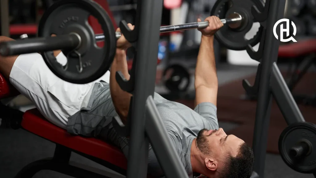 Man in gray shirt doing decline barbell bench press