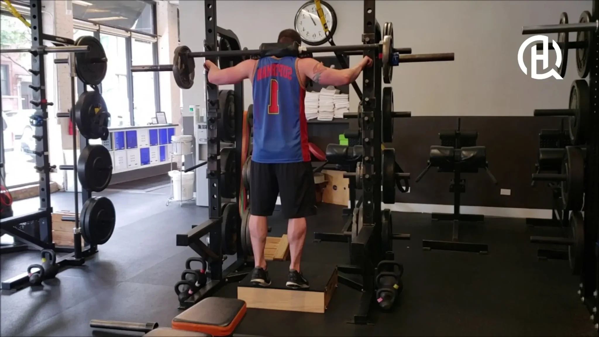 A man doing a calf raise with a barbell