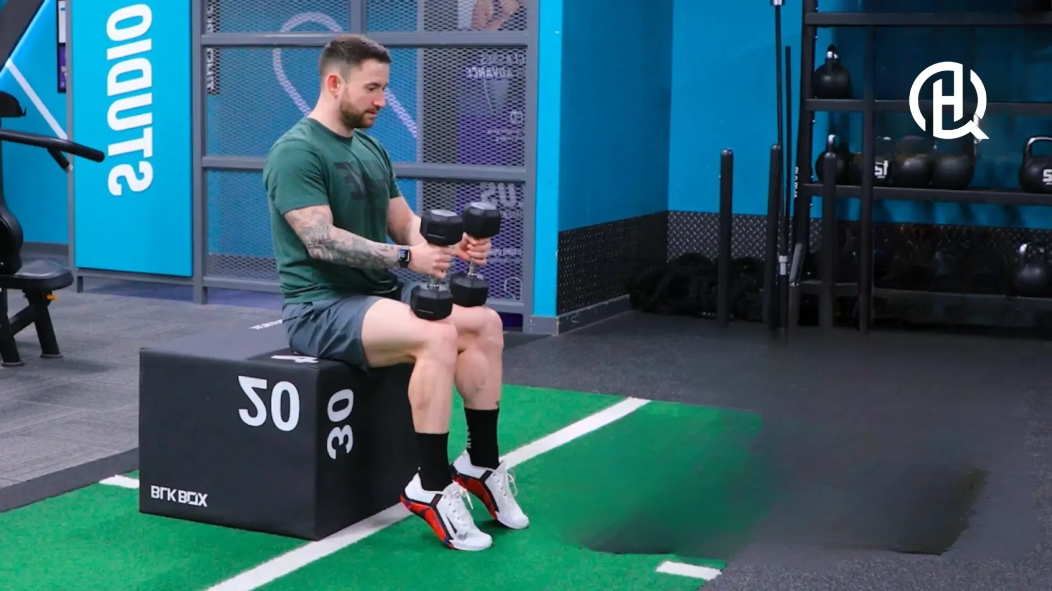 A man doing seated calf raise with dumbbells on his lap