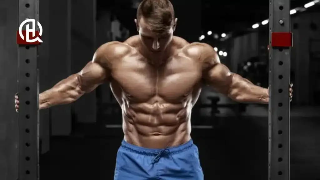Topless guy flexing his chest in a gym