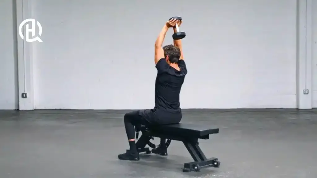 Man in black tshirt doing Dumbbell Overhead Triceps Extension