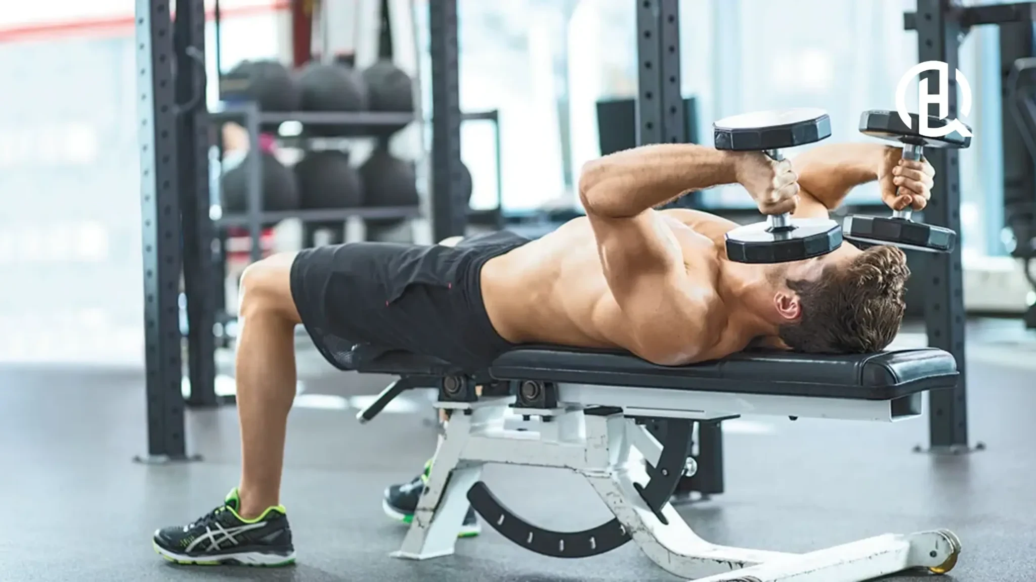 A man lying on a bench doing triceps extension