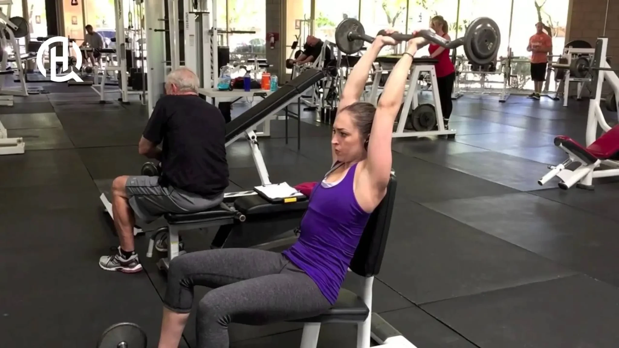 Woman demonstrating full triceps stretch during French press